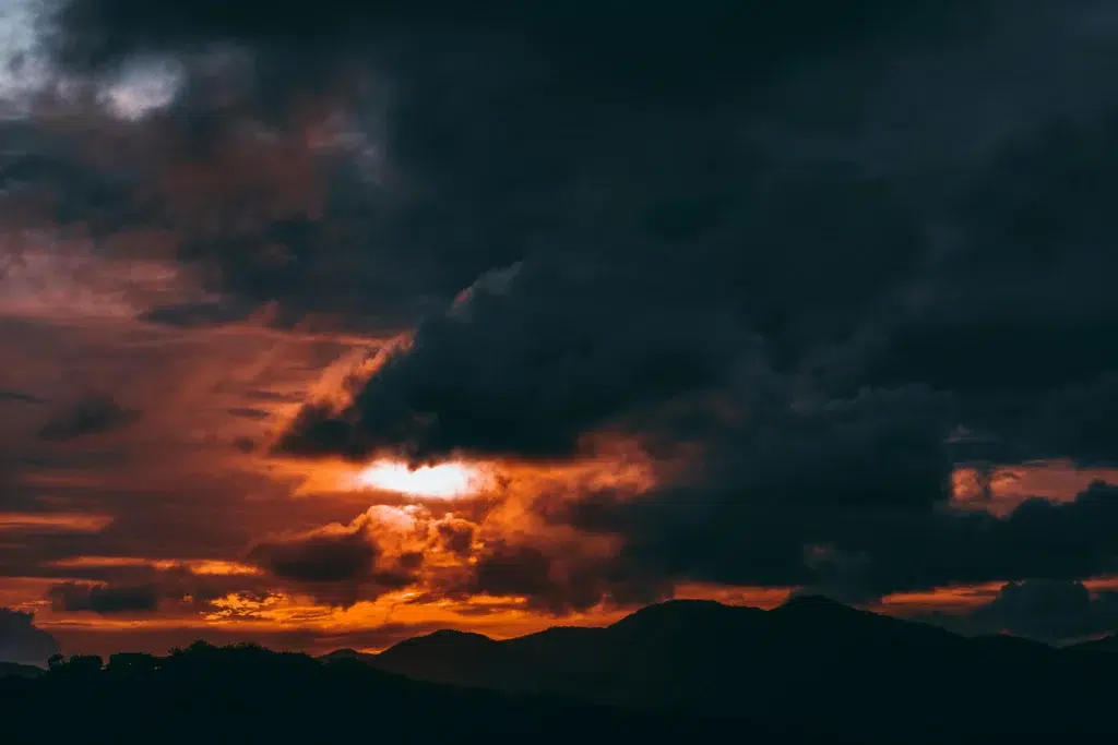 Ciel orageux et coucher de soleil sur les collines d’Antigua-et-Barbuda, illustrant la variabilité du climat local entre saisons ensoleillées et périodes plus nuageuses.