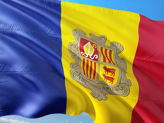 Le drapeau de l’Andorre flottant sur fond de ciel bleu, avec ses bandes bleu, jaune et rouge et ses armoiries au centre symbolisant l’indépendance et l’identité du pays.