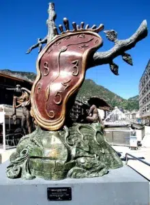 Sculpture de l’horloge fondue de Salvador Dalí à Andorre-la-Vieille, symbole culturel dans un pays où la langue officielle est le catalan.