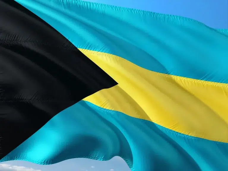 Drapeau des Bahamas bleu, noir et jaune flottant dans le ciel, symbole national et identitaire de l’archipel.