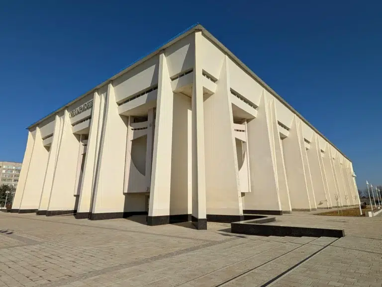 Vue d’un bâtiment administratif moderne à Maïkop, sous un ciel bleu clair.