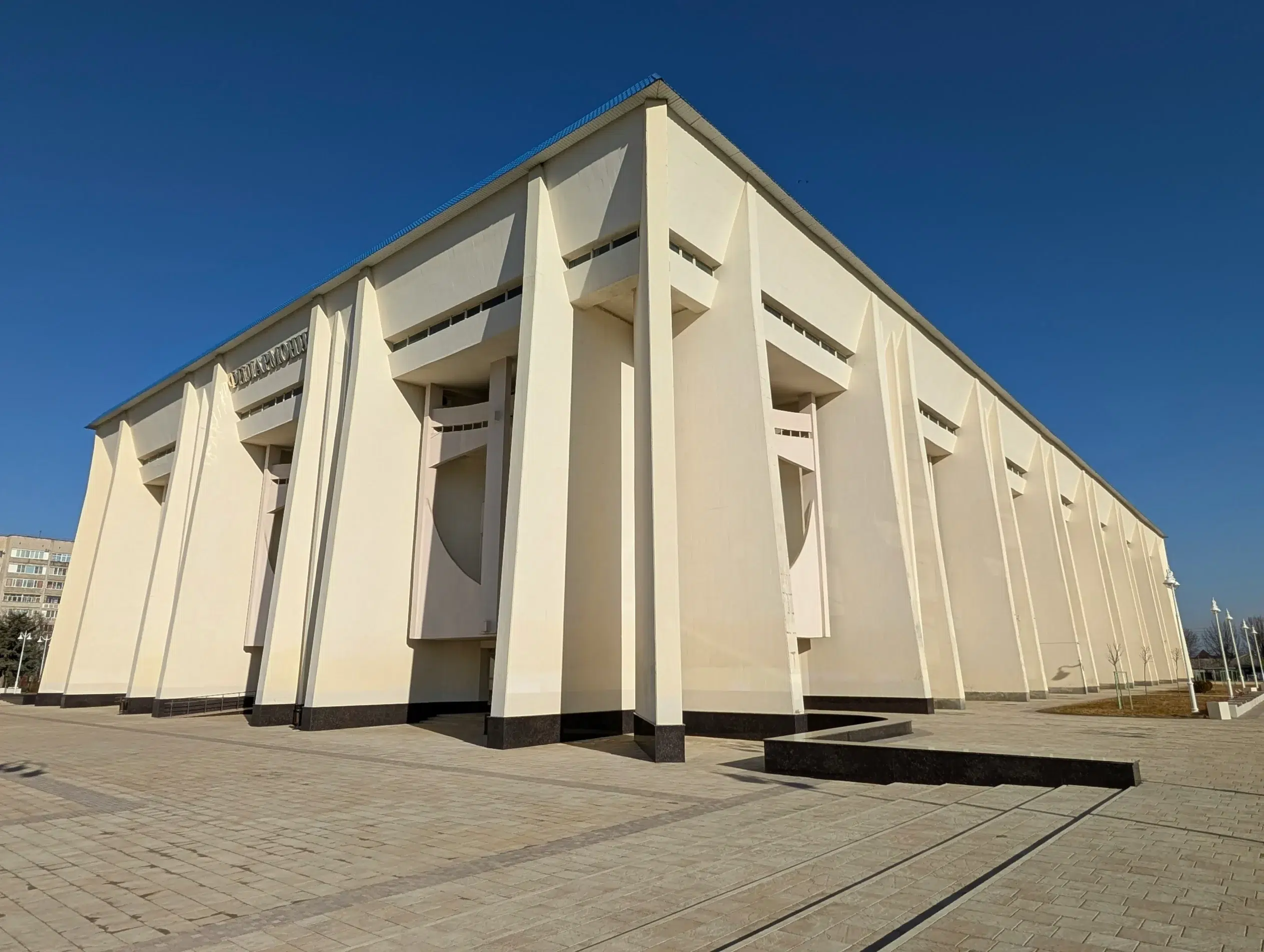 Vue d’un bâtiment administratif moderne à Maïkop, sous un ciel bleu clair.