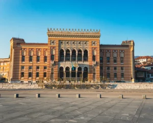 Bibliothèque nationale de Sarajevo (Vijećnica), emblématique bâtiment historique de la capitale de la Bosnie-Herzégovine, avec ciel bleu en arrière-plan.
