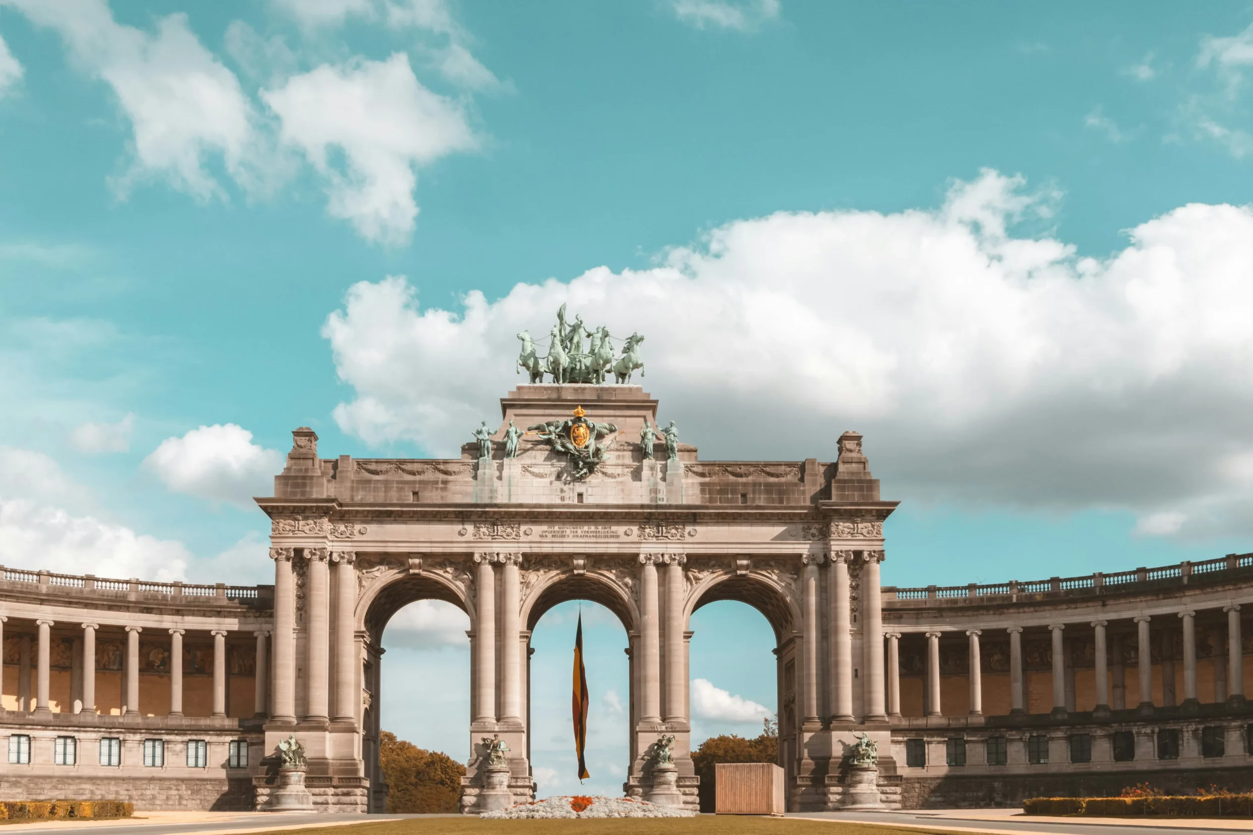 Arc de Triomphe du Parc du Cinquantenaire à Bruxelles, capitale de la Belgique, sous un ciel bleu parsemé de nuages.