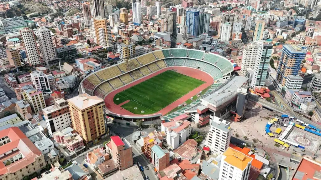 Vue aérienne du stade Hernando Siles à La Paz, capitale administrative de la Bolivie, entourée de buildings colorés dans un paysage montagneux.