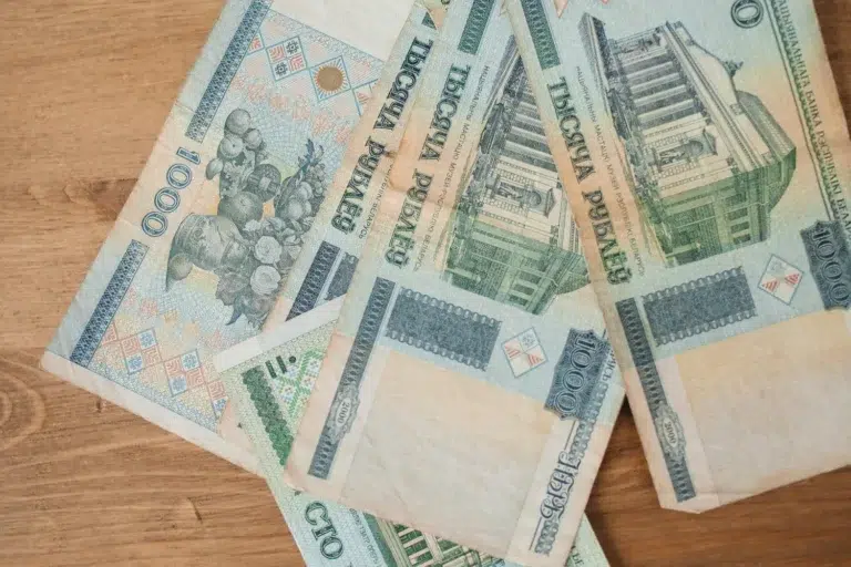 Billets en roubles biélorusses anciens étalés sur une table en bois, représentant la monnaie Biélorussie avant la dernière réforme monétaire