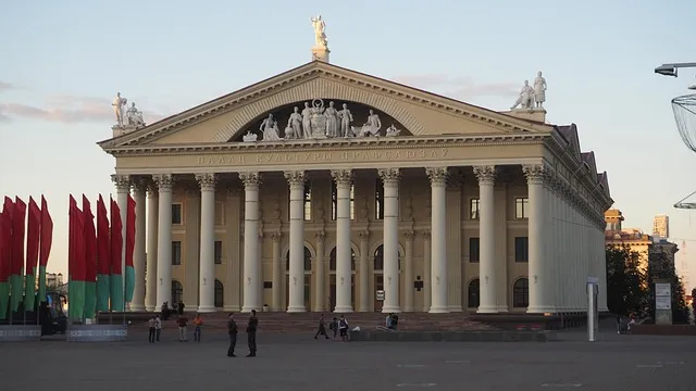Façade majestueuse du Palais de la culture à Minsk, Biélorussie, illustrant l’architecture soviétique et la présence des langues biélorusse et russe dans l’espace public.