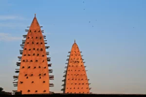 Minarets en banco de la grande mosquée de Bobo Dioulasso au Burkina Faso, architecture traditionnelle sahélienne au coucher du soleil.