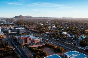 Vue aérienne de la ville de Gaborone au Botswana avec ses bâtiments modernes, routes et quartiers résidentiels sous un ciel dégagé.