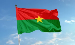 Drapeau du Burkina Faso, composé de deux bandes rouge et verte avec une étoile jaune au centre, flottant sur fond de ciel bleu.