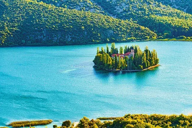 Petite île avec monastère au milieu d’un lac turquoise en Croatie, paysage pittoresque et paisible.