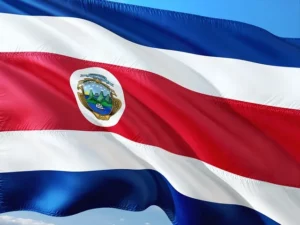 Drapeau du Costa Rica flottant au vent avec ses bandes bleues, blanches et rouges et ses armoiries