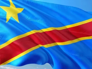 Drapeau officiel de la République Démocratique du Congo flottant sous un ciel bleu.