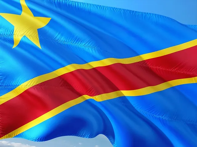 Drapeau officiel de la République Démocratique du Congo flottant sous un ciel bleu.