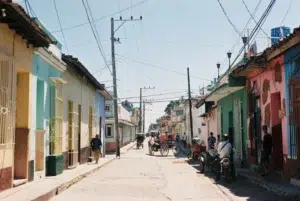 Rue typique de Cuba avec habitants et maisons colorées, reflet du quotidien où l’espagnol est la langue principale.