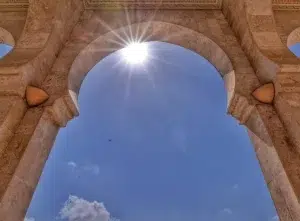 Arc d’une mosquée au Congo-Brazzaville avec le soleil brillant dans le ciel bleu.