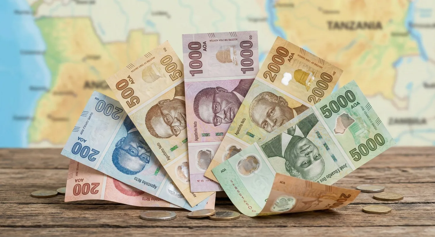 Billets de kwanza étalés sur une table avec carte en arrière-plan, représentant la monnaie Angola et ses différentes valeurs.
