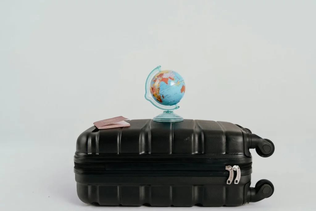 faire la hijra avec un globe et un passeport sur une valise